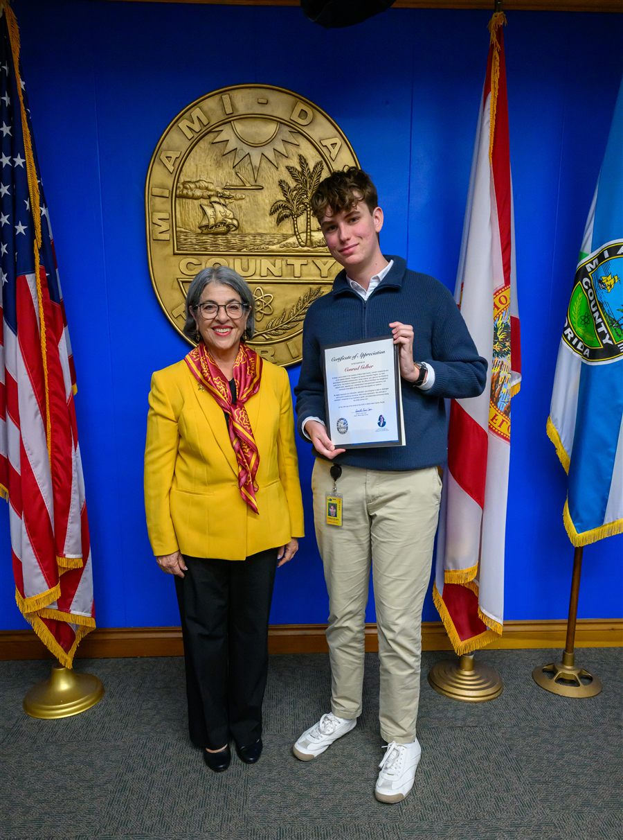 Conrad Gelber standing with Miami-Dade County Mayor Daniella Levine-Cava, holding a certificate of appreciation, at the Stephen P. Clark Center